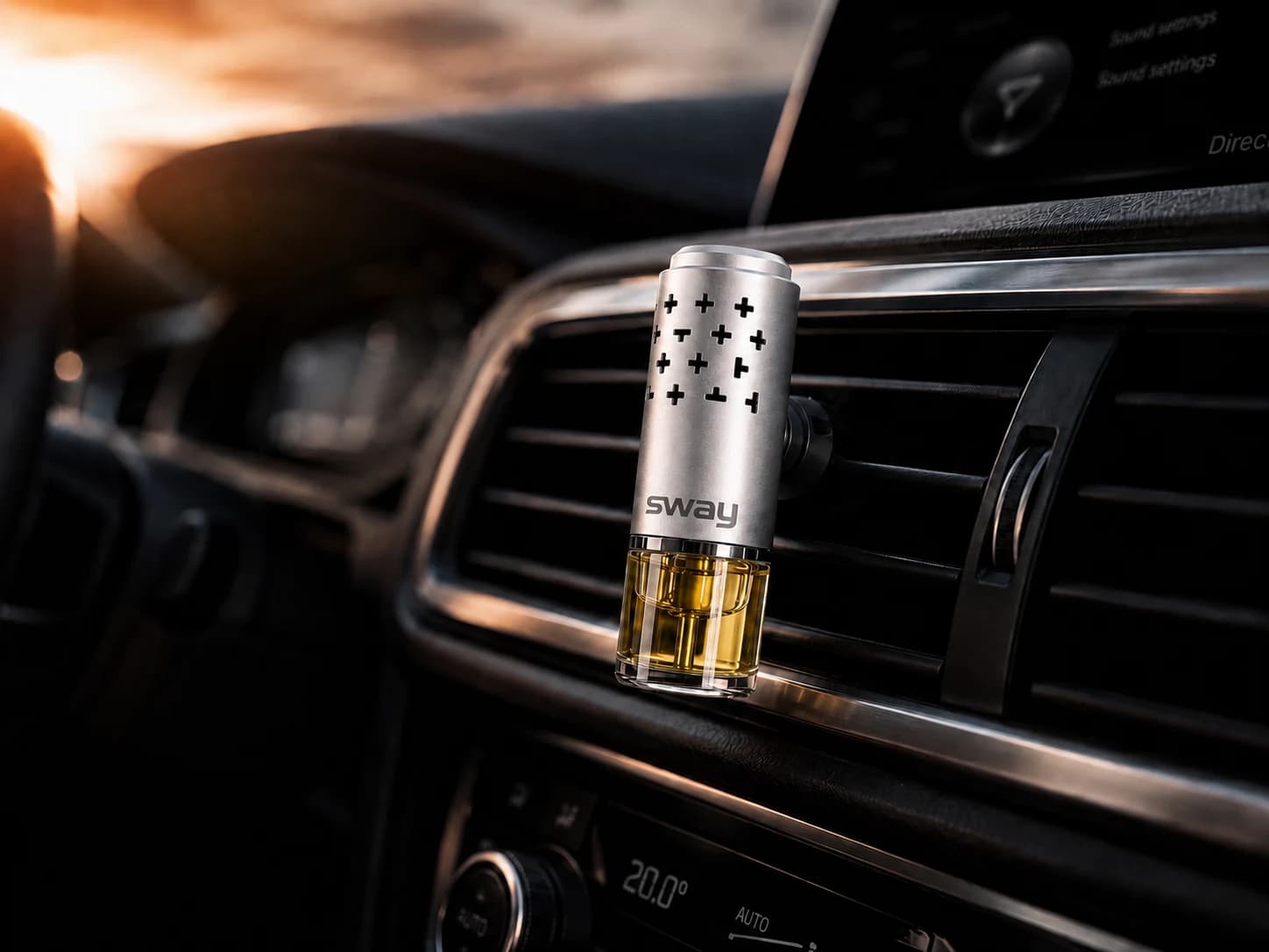 Sway diffuser clipped into a luxury car vent at golden hour